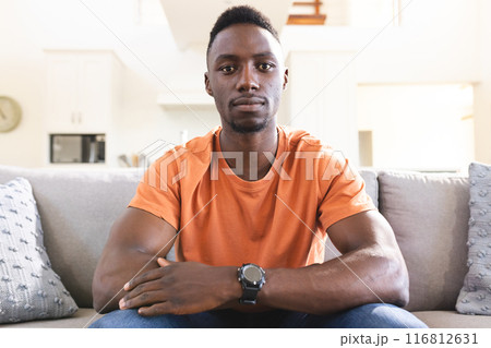 Serious african american man having video call, sitting on sofa at home listening Serious african american man having video call, sitting on sofa at home listening 116812631
