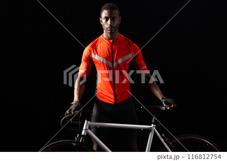 African American man poses with his bicycle on a black background, with copy space 116812754