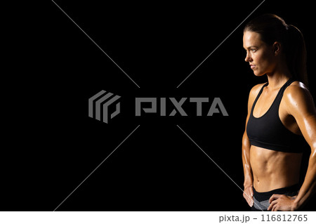 Athletic woman showcases health dedication on black background. 116812765