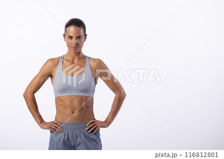 A confident young Caucasian female athlete poses, white background, copy space 116812801