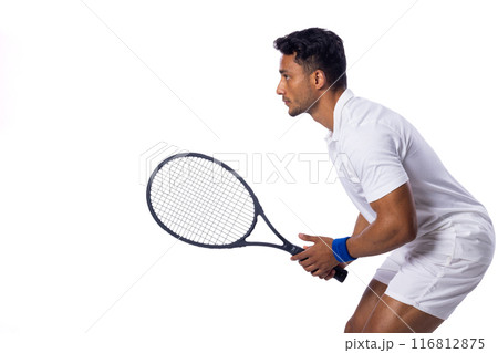 Focused biracial man playing tennis indoors on a white background, with copy space 116812875
