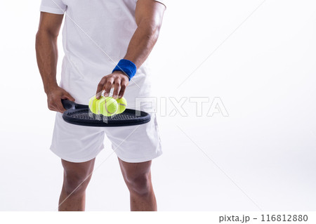 Biracial man prepares for a tennis match on a white background, with copy space 116812880
