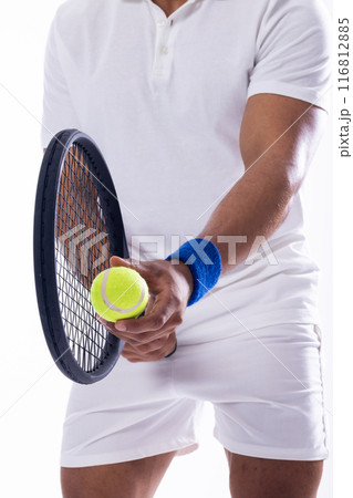 Young biracial man ready to serve in a tennis match on a white background 116812885