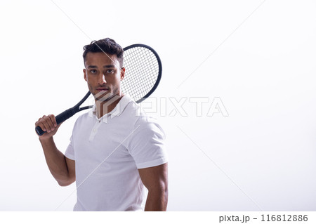 Young biracial man poses with a tennis racket on a white background, with copy space 116812886