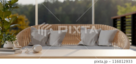 A wooden coffee table in a contemporary living room with a wicker sofa. image with a copy space 116812933