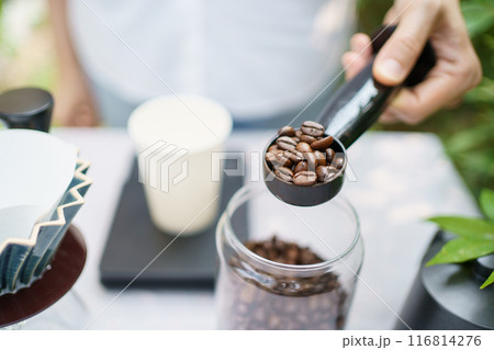 Happy Asian beautiful woman making a specialty coffee in morning at her backyard garden, woman brewing a coffee by dripping or pouring over a hot water. 116814276