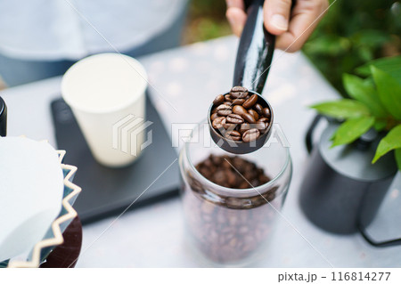 Happy Asian beautiful woman making a specialty coffee in morning at her backyard garden, woman brewing a coffee by dripping or pouring over a hot water. 116814277