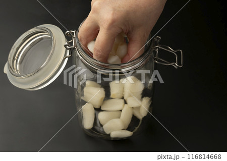 らっきょうを漬ける　瓶にらっきょう、唐辛子を入れる 116814668