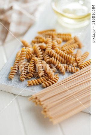 Uncooked whole grain pasta. Raw fusilli and spaghetti. Uncooked whole grain pasta. Raw fusilli and spaghetti. 116816594