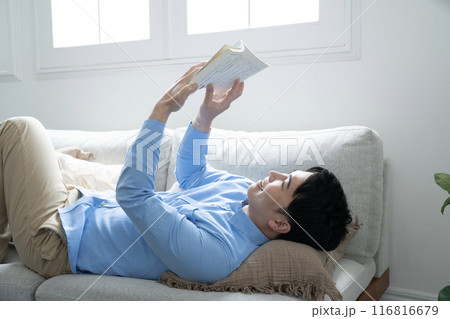 ソファーに寝転んで読書をする男性 ソファーに寝転んで読書をする男性 116816679