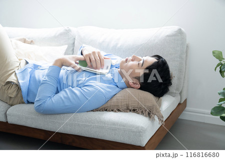 ソファーに寝転んで眠る男性 116816680