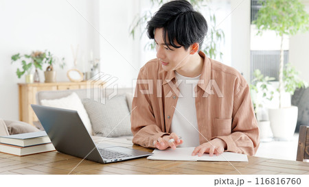 自宅で資格の勉強をする男性 116816760