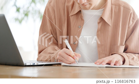 自宅で資格の勉強をする男性 116816763