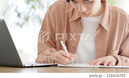 自宅で資格の勉強をする男性 116816765