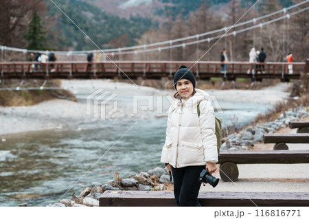 Woman tourist travel Kamikochi National Park, happy Traveler sightseeing Kappa bashi bridge, Nagano Prefecture, Japan. Landmark for tourists attraction. Japan Travel, Destination and Vacation concept 116816771