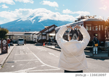 Woman tourist with Fuji Mountain at Kawaguchiko train station, happy Traveler sightseeing Mount Fuji in Yamanashi, Japan. Landmark for tourists attraction. Japan Travel, Destination and Vacation 116818097
