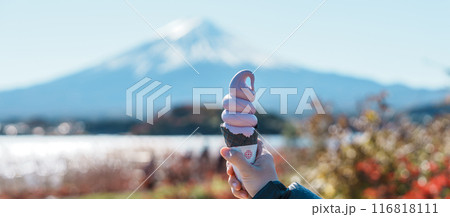Woman hand holding ice cream in a cone with Mt Fuji at Lake Kawaguchi, happy Traveler sightseeing Mount Fuji in Oishi park. Landmark for tourists attraction. Japan Travel, Destination and Vacation Woman hand holding ice cream in a cone with Mt Fuji at Lake Kawaguchi, happy Traveler sightseeing Mount Fuji in Oishi park. Landmark for tourists attraction. Japan Travel, Destination and Vacation 116818111
