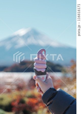 Woman hand holding ice cream in a cone with Mt Fuji at Lake Kawaguchi, happy Traveler sightseeing Mount Fuji in Oishi park. Landmark for tourists attraction. Japan Travel, Destination and Vacation Woman hand holding ice cream in a cone with Mt Fuji at Lake Kawaguchi, happy Traveler sightseeing Mount Fuji in Oishi park. Landmark for tourists attraction. Japan Travel, Destination and Vacation 116818171