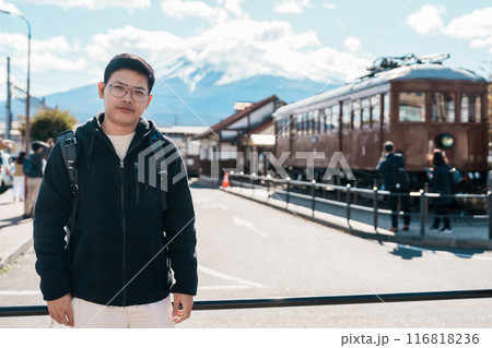 man tourist with Fuji Mountain at Kawaguchiko train station, happy Traveler sightseeing Mount Fuji in Yamanashi, Japan. Landmark for tourists attraction. Japan Travel, Destination and Vacation 116818236