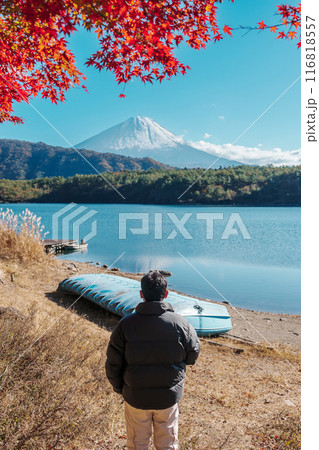 man tourist with Fuji Mountain at Lake Saiko in Autumn season, happy Traveler travel Mount Fuji, Yamanashi, Japan. Landmark for tourists attraction. Japan Travel, Destination and Vacation 116818557