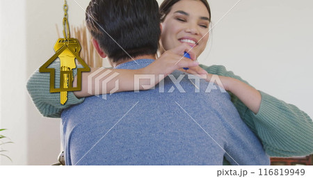 Image of gold house key and key fob over happy diverse couple at new home 116819949