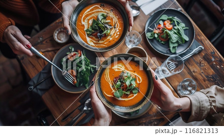 Wooden table, top view, pumpkin soup in plates, passed by human hands Wooden table, top view, pumpkin soup in plates, passed by human hands 116821313