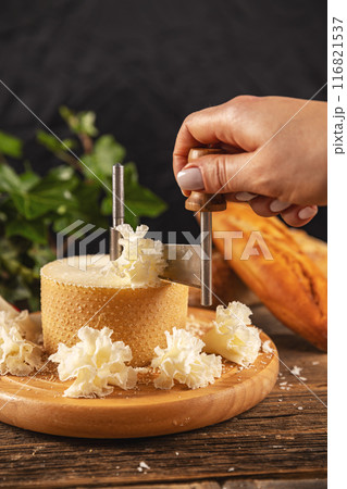 Woman slicing cheese with girolle 116821537