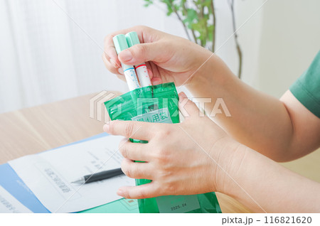 検便容器を袋に入れる女性 116821620