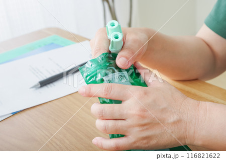 検便容器を袋に入れる女性 116821622