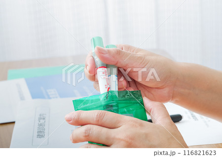 検便容器を袋に入れる女性 116821623
