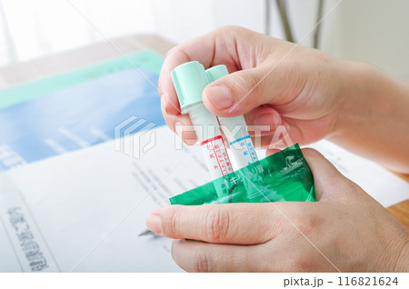 検便容器を袋に入れる女性 116821624