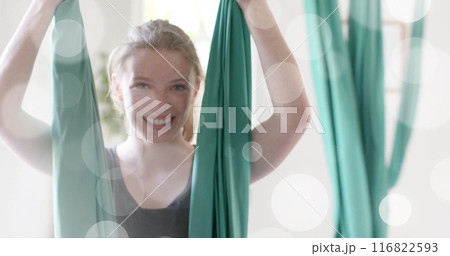 Image of light spots over happy caucasian teenage girl practicing aerial yoga Image of light spots over happy caucasian teenage girl practicing aerial yoga 116822593