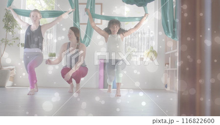 Image of white light spots over diverse female instructor and teenage girls doing aerial yoga Image of white light spots over diverse female instructor and teenage girls doing aerial yoga 116822600