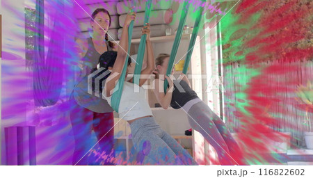 Image of colourful trails over diverse female instructor and teenage girls doing aerial yoga Image of colourful trails over diverse female instructor and teenage girls doing aerial yoga 116822602