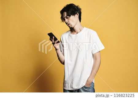 カラーバックでスマホを触る男性 カラーバックでスマホを触る男性 116823225