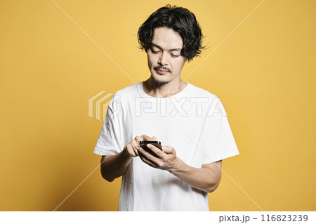 カラーバックでスマホを触る男性 カラーバックでスマホを触る男性 116823239