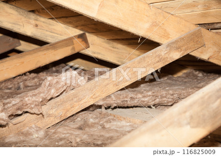 Construction worker thermally insulating house mineral wool attic with glass wool Construction worker thermally insulating house mineral wool attic with glass wool 116825009