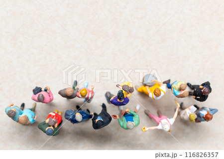 Top-down view of a group of miniature people showing different clothing and poses. 116826357