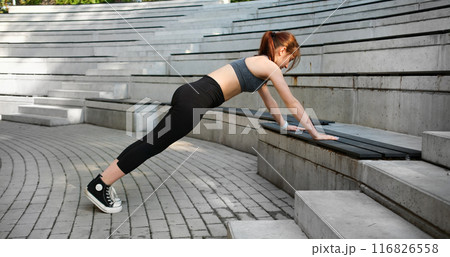 Girl Doing Push-Ups Outside As Part Of Training And Female Bodybuilding Routine Girl Doing Push-Ups Outside As Part Of Training And Female Bodybuilding Routine 116826558