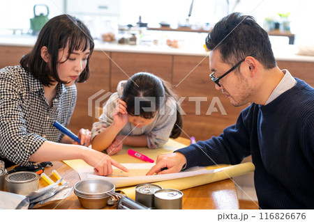 お父さんが司会となって災害発生時の避難場所等についてハザードマップを見ながら家族で話し合っている様子 お父さんが司会となって災害発生時の避難場所等についてハザードマップを見ながら家族で話し合っている様子 116826676