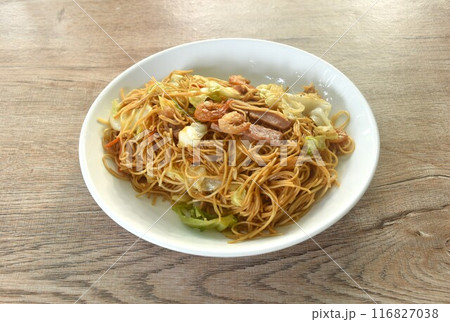 stir fried Hong Kong noodles cabbage and meat with slice bacon topping dry shrimp on plate stir fried Hong Kong noodles cabbage and meat with slice bacon topping dry shrimp on plate 116827038