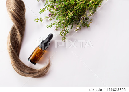 Fresh thyme, essential oil and hair isolated on the white background. Hair treatment concept. Flat lay Fresh thyme, essential oil and hair isolated on the white background. Hair treatment concept. Flat lay 116828763