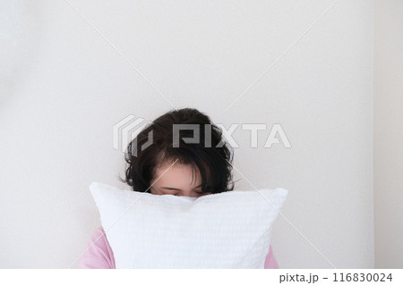 枕を抱えて心を体を整えるミドル女性 116830024