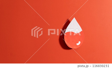 Blood drop with low blood level made from paper on red background. Concept of hematologic disorders such as anemia, sickle cell disease, hemophilia, leukemia and ITP. 116830231