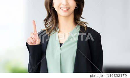 人差し指を立てて案内する笑顔の日本人ビジネスウーマン 116832179