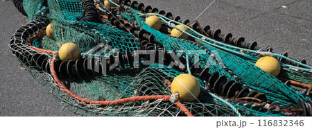 Detail of a colorful big fishing net drying in the harbour of Hirtshals, Denmark. Detail of a colorful big fishing net drying in the harbour of Hirtshals, Denmark. 116832346