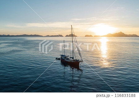 Aerial view of a sailboat anchored in the Philippines at sunset. 116833188