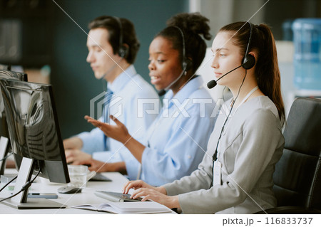 Team of young biracial operators having callsat work in office of modern company 116833737