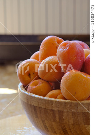 a group of ripe apricots on a wooden plate a group of ripe apricots on a wooden plate 116834475