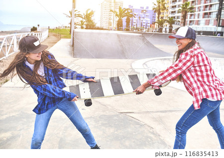 Angry girls fighting for a skateboard in skate park. friends doing wrestling parody. Angry girls fighting for a skateboard in skate park. friends doing wrestling parody. 116835413